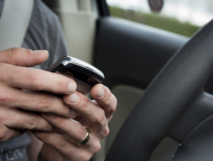 איש מחזיק סלולרי בתוך הרכב (צילום: אימג'בנק / Thinkstock)