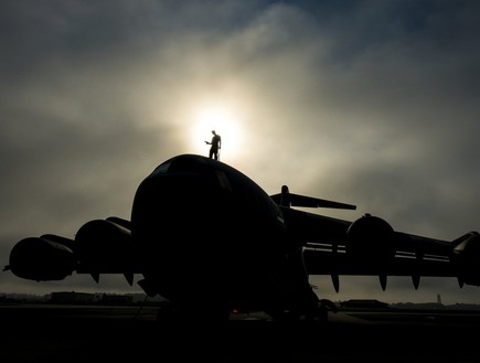 מפקד טייסת צועד על גג מטוס תובלה (צילום: דניס סלואן, חיל האוויר האמריקאי)