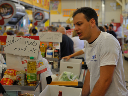 מתנדב בחלוקת סלי המזון (צילום: ענת כהן)
