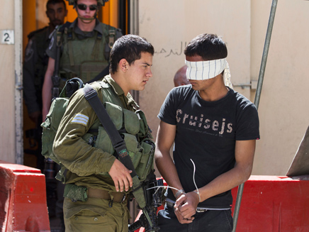 חייל ישראלי ועצור פלסטינאי (צילום: רויטרס)