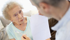 איש מחזיק נייר ועט מול אישה מבוגרת בתכלת (צילום: jupiter images)