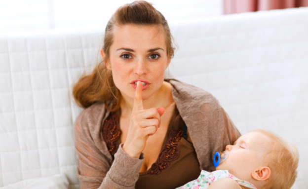 אמא מחזיקה תינוק מבקשת שקט (צילום: אימג'בנק / Thinkstock)