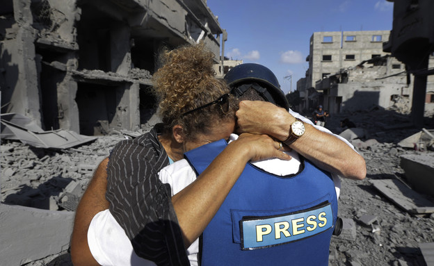 עיתונאי זר מחבק עיתונאית פלסטינית (צילום: ap)