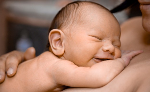 תינוק בן יומו שוכב על אמו (צילום: istockphoto)