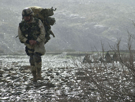 חובש אמריקאי צועד בגשם באפגניסטן במבצע לאיתור אמל