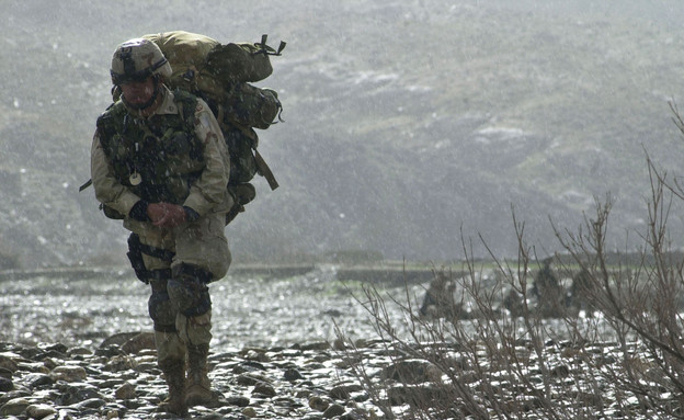 חובש אמריקאי צועד בגשם באפגניסטן במבצע לאיתור אמל
