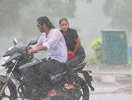 זוג על אופנוע בגשם (צילום: hindutimes)