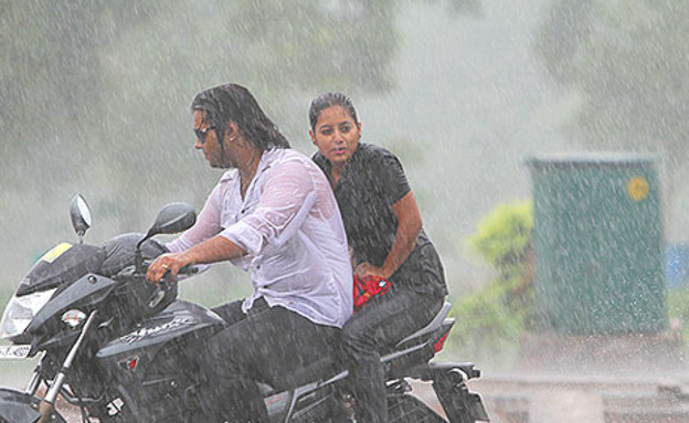 זוג על אופנוע בגשם (צילום: hindutimes)