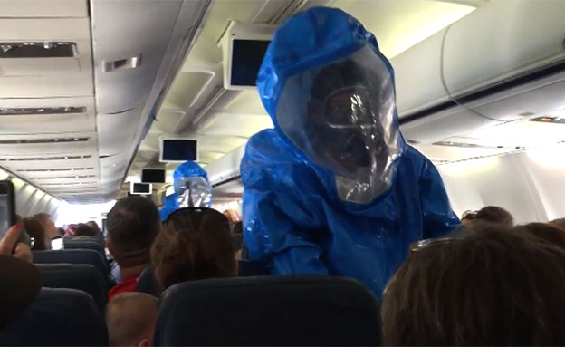 טיפול בחשש להתפרצות הנגיף במטוס (צילום: יוטיוב)