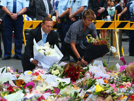 אבוט ואשתו הניחו פרח לזכר הקורבנות (צילום: AP)
