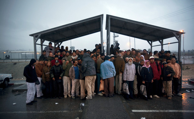 פועלים פלסטיניים מחכים להסעה לאחר יום עבודה בישראל (צילום: ap)