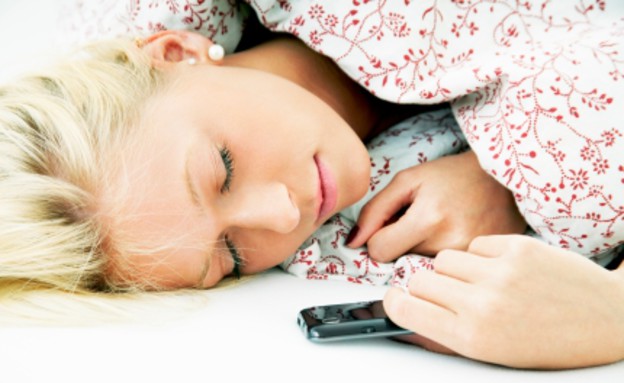 אישה ישנה עם טלפון סלולרי (צילום: Michael Bodmann, Istock)