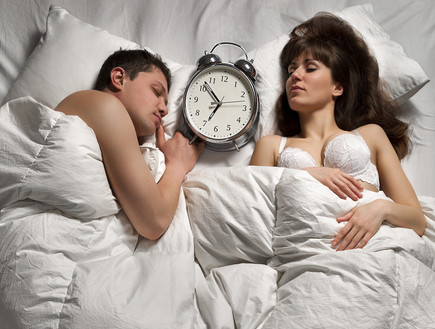 זוג במיטה עם שעון (צילום: Thinkstock)