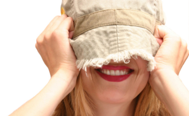 אישה נבוכה - כובע על הפנים (צילום: Sharon Dominick, Istock)
