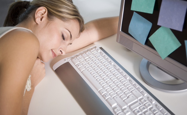 עייפות ותזונה-אישה ישנה על שולחן מחשב לצד מקלדת (צילום: istockphoto)