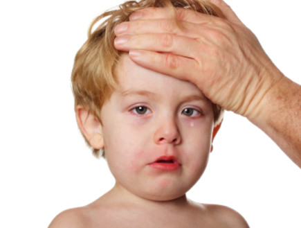 יד גברית על מצח של ילד בלונדיני בוכה וחולה (צילום: istockphoto)