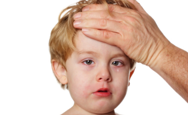 יד גברית על מצח של ילד בלונדיני בוכה וחולה (צילום: istockphoto)