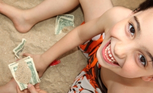 ילד בחוף הים מחזיק כסף (צילום: אימג'בנק / Thinkstock)