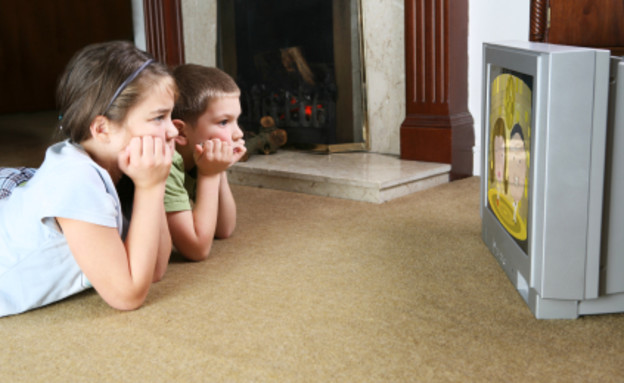 ילדים שוכבים על השטיח וצופים בטלויזיה (צילום: dorioconnell, Istock)