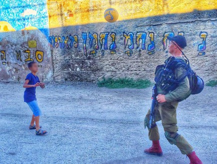 חייל כפיר משחק עם ילד (צילום: מתוך דף הפייסבוק של ויצה סיבנקוב)