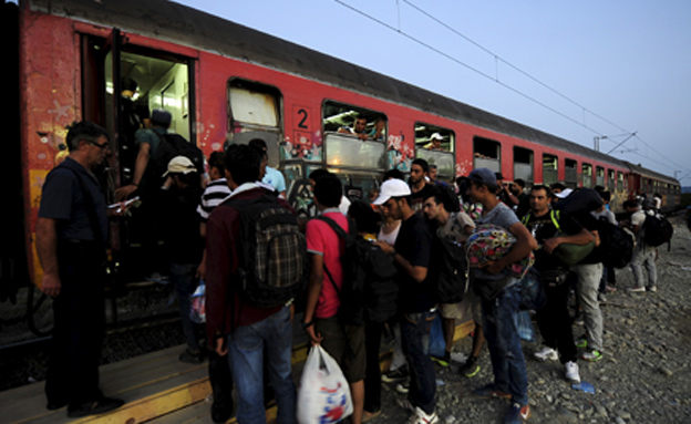 מהגרים מנסים לעלות על רכבת בהונגריה (צילום: רויטרס)