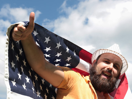 גבר עם זקן מחזיק את דגל ארצות הברית (צילום: אימג'בנק / Thinkstock)