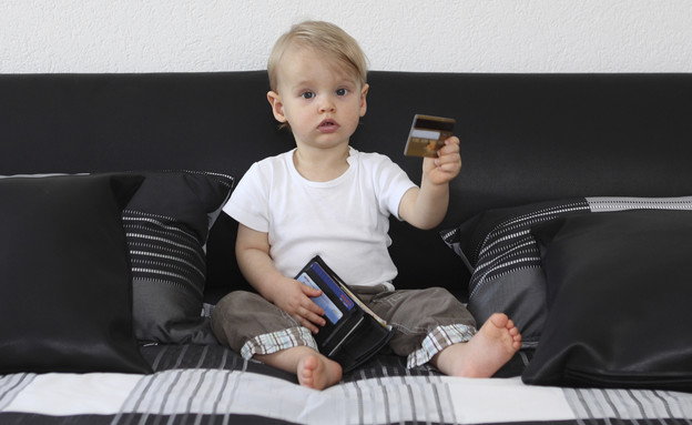 תינוק יושב על ספה ומחזיק כרטיסי אשראי (אילוסטרציה: Snejana_1974, Thinkstock)