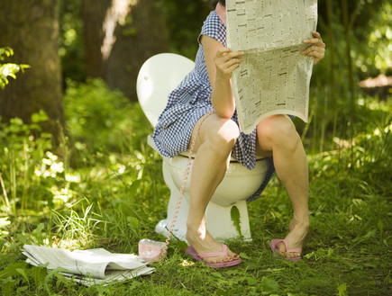 אישה בשירותים קוראת עיתון (צילום: אימג'בנק / Thinkstock)