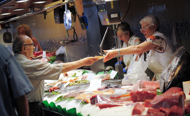 לקוח בשוק הדגים של ברצלונה משלם במזומן (צילום: David Ramos, GettyImages IL)