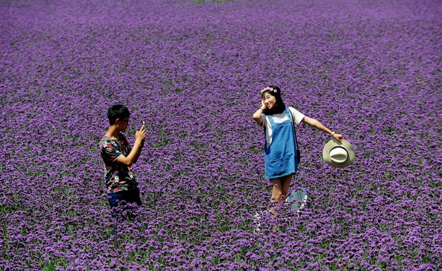 12.8 שני צעירים בשדה פרחים בסין (צילום: אימג'בנק/AFP)