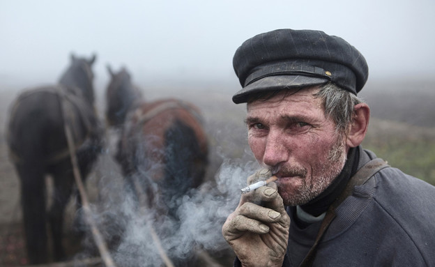 איכר בהפסקת סיגריה, רמניה (צילום: Mitchell Kanashkevich / www.tpoty.com)