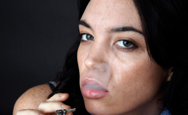 אישה מעשנת ג'וינט (צילום: John Sommer, Istock)
