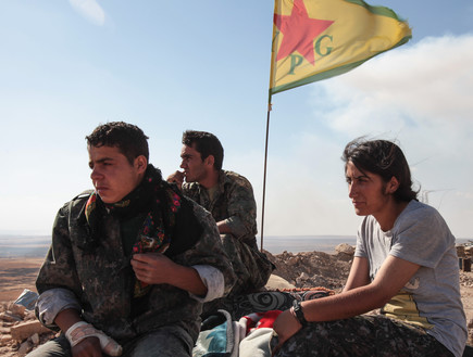 A Kurdish People's Protection Units, or YPG fighters stand near a  (צילום: Ahmet Sik, GettyImages IL)