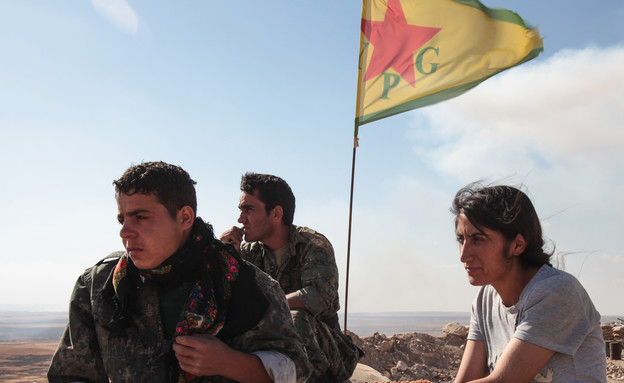 A Kurdish People's Protection Units, or YPG fighters stand near a  (צילום: Ahmet Sik, GettyImages IL)