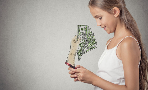 נערה גולשת בסמארטפון ומקבלת כסף (אילוסטרציה: Shutterstock)