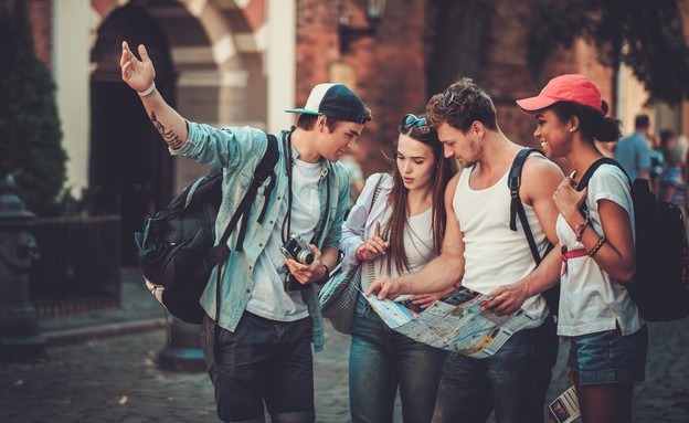 קבוצת צעירים מטיילת בחו"ל עם מפה ומצלמה (צילום: Nejron Photo, Shutterstock)