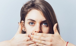 אישה שמה יד על הפה (צילום: Shutterstock)