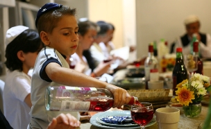 ילד מוזג יין תירוש במהלך ארוחת ליל הסדר (צילום: חן ליאופולד, פלאש 90)