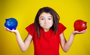 ילדה מבולבלת מחזיקה שתי קופות חיסכון (אילוסטרציה: Shutterstock)