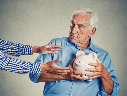 גבר מבוגר מנסה להגן על קופת החיסכון שלו (אילוסטרציה: Shutterstock)