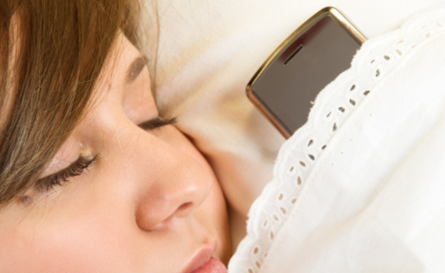 ישנה עם טלפון סלולרי (צילום: אימג'בנק / Thinkstock)