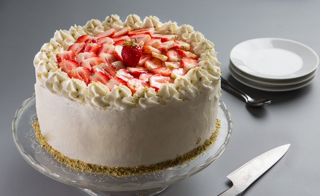 מקשטים את העוגה בפרוסות תותים מקשטים את העוגה בפרוסות תותים