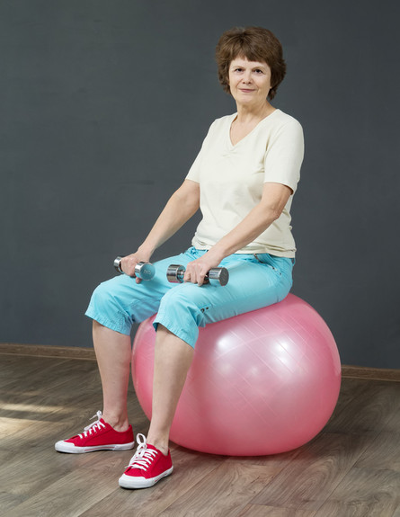 אישה מבוגרת על כדור פילאטיס (צילום: Ogovorka, Shutterstock)