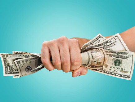 יד מחזיקה שטרות כסף (אילוסטרציה: Shutterstock)