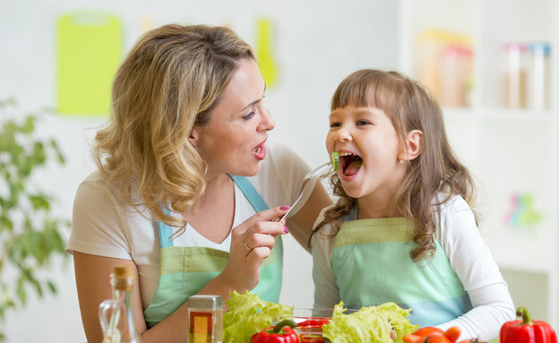 אמא מאכילה ילדה (צילום: Oksana Kuzmina, Shutterstock)