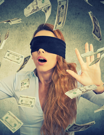 אישה עם עיניים קשורות מנסה לתפוס שטרות כסף (אילוסטרציה: Shutterstock)