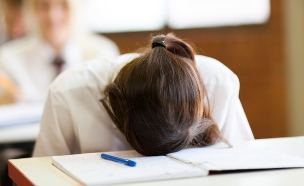 תלמידה מיואשת עם הראש על השולחן (אילוסטרציה: Shutterstock)
