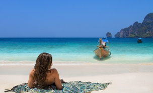 אישה יושבת על חוף בתאילנד (צילום: Netfalls - Remy Musser, Shutterstock)