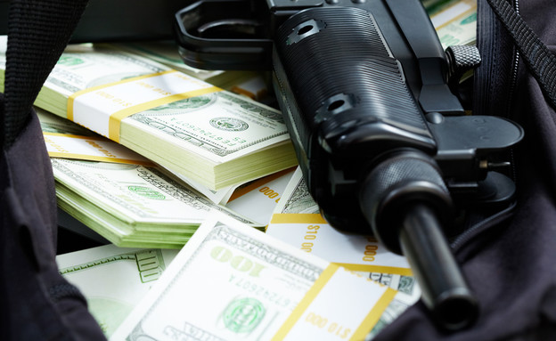 תת מקלע מונח על שטרות כסף (אילוסטרציה: Shutterstock)