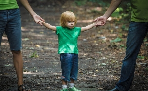 ילד מחזיק בידיים של הוריו (אילוסטרציה: Shutterstock)